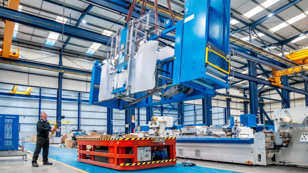 Crane lifting heavy machinery during the decommissioning of an industrial space.