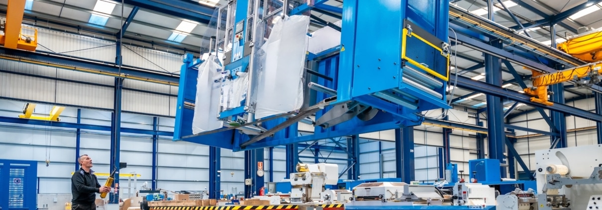 Crane lifting heavy machinery during the decommissioning of an industrial space.