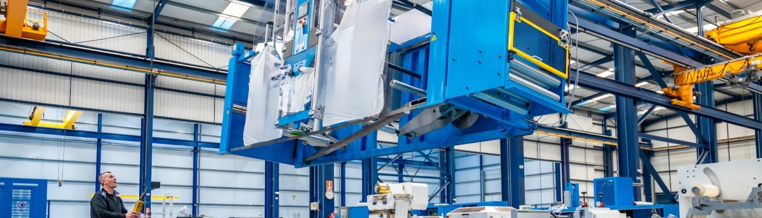 Crane lifting heavy machinery during the decommissioning of an industrial space.
