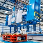 Crane lifting heavy machinery during the decommissioning of an industrial space.