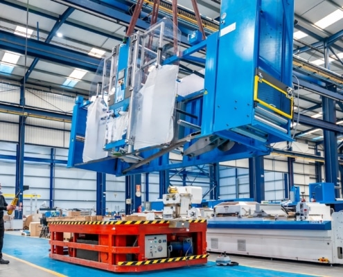 Crane lifting heavy machinery during the decommissioning of an industrial space.